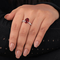 Close-up of a hand wearing a ring with a red gemstone on a black background, Romantic Garnet Style Wedding Ring For Women, Vintage Inspired Garnet Engagement Band, Unique Red CZ Stone Halo Engagement Ring