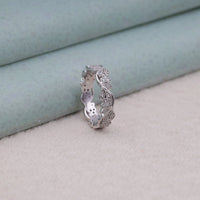 Silver ring with intricate design on a soft fabric background, moissanite fine jewelry, unique bridal ring, vintage-inspired moissanite jewelry, handcrafted eternity ring, moissanite band gift for her