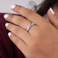 Silver ring on a person's finger with a blurred background, milgrain moissanite ring, vintage eternity band, art deco leaf ring, leaf motif wedding band, moissanite eternity band, round moissanite ring, antique inspired ring, moissanite wedding band, ethical moissanite jewelry