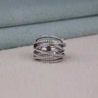 Stack of silver rings with embedded stones on a soft surface