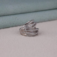 Silver ring with multiple bands on a light gray surface