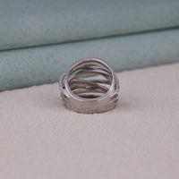 Stack of silver rings on a textured surface with a blurred background