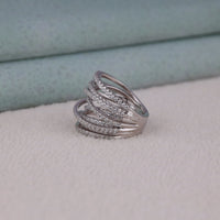 Silver ring with multiple bands on a light gray surface