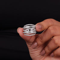 Hand holding multiple silver rings with a black background