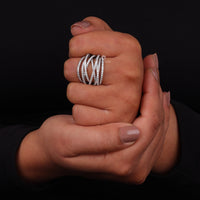 Hand wearing a silver ring on a black background