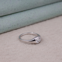 Silver ring with a diamond on a textured surface, Contemporary Flush Setting Oval Moissanite Engagement Ring for Women, Modern Oval Cut Moissanite Wedding Ring