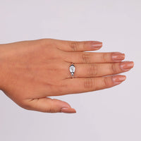 Hand wearing a silver ring with a teardrop-shaped gemstone on a light gray background, Contemporary Flush Setting Oval Moissanite Engagement Ring for Women