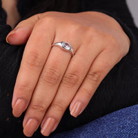 Close-up of a hand wearing a silver ring with a clear gemstone on a dark background, Oval Moissanite Flush Set Engagement Ring, Modern Solitaire Wedding Band