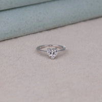 Heart-shaped diamond ring on a light gray surface, Sparkling Heart Moissanite Proposal Ring, Modern Classic Heart Engagement Jewelry