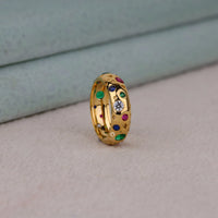 Gold ring with colorful gemstones on a light gray surface, Colorful Round CZ Star Ring – Celestial Flush Set Stacking Band for Women