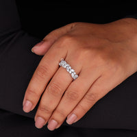 Hand wearing a diamond ring on a black background