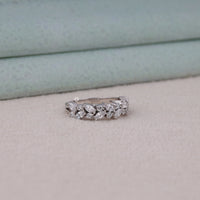 Silver ring with diamonds on a light gray surface