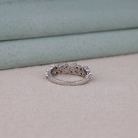 Silver ring with intricate design on a light gray surface
