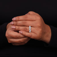 Close-up of a hand wearing a diamond ring on a black background