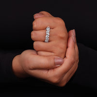 Hand wearing a diamond ring with a black background
