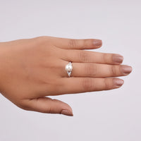 Hand wearing a pearl ring on a plain background, daily wear Moissanite jewelry, timeless Moissanite ring, pearl and stone ring, Moissanite stacking ring, romantic Moissanite jewelry, gold and pearl ring, handcrafted Moissanite ring, botanical Moissanite ring