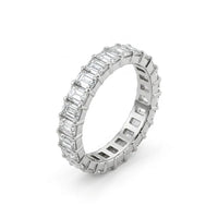 Diamond ring with emerald-cut and baguette-cut diamonds on a white background