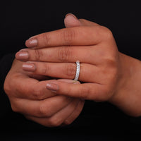 Close-up of hands with a diamond ring on a black background