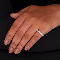 Hand wearing a diamond ring on a black background