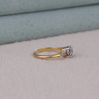 Gold ring with a diamond on a light gray surface