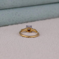 Gold ring with a diamond on a light gray surface