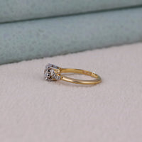 Gold ring with diamonds on a light gray surface