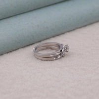 Two silver rings stacked on a textured surface with a light blue background, old world inspired ring set, alternative engagement ring set, vintage promise ring set, 14K gold moissanite set, round cut wedding rings