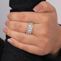 Close-up of a hand wearing a silver ring with multiple diamonds on a neutral background, Durable Bezel Set Moissanite Wedding Band, Unique Bubble Style Fashion Ring For Women, Affordable Moissanite Bridal Eternity Ring