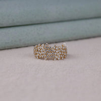 Gold ring with diamond accents on a soft surface