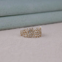 Gold ring with clear stones on a light background