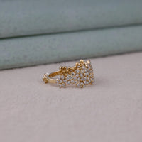 Gold ring with diamond accents on a neutral background