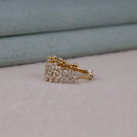 Gold ring with diamonds on a light gray surface