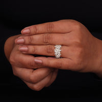 Close-up of a hand wearing a diamond ring on a black background