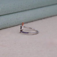 Silver ring with purple stones on a person's finger against a neutral background, Monster-Inspired Statement Ring – Amethyst & Black Onyx CZ Round Cut Stones