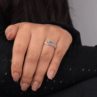 Close-up of a hand wearing a diamond ring on a neutral background, “Minimalist Aquamarine Three Stone Ring, Baguette, Round & Triangle CZ Dainty Band