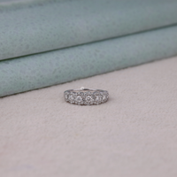 Silver ring with diamonds on a light gray surface, White Gold Seven Stone Halo Engagement Ring – Round Brilliant Moissanite Ring