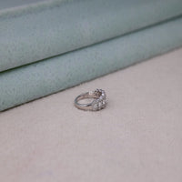 Silver ring with gemstones on a textured surface, Classic Seven Stone Round Moissanite Engagement Ring – Halo Wedding Ring