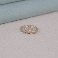 Gold ring with diamond accents on a light gray surface, Classic Edwardian Wedding Jewelry For Brides, Moissanite Anniversary Ring With Fan Design