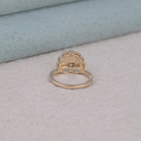 Gold ring with intricate design on a light gray surface, Affordable Vintage Style Engagement Ring, Romantic Edwardian Moissanite Bridal Jewelry, Symbolic Antique Moissanite Ring For Women