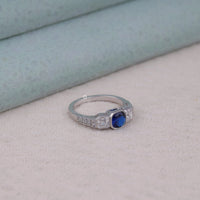 Silver ring with a blue gemstone on a light gray surface, Affordable Art Deco Ring, Retro Inspired Engagement Ring