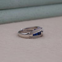 Silver ring with blue stones on a beige surface