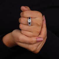Hand wearing a diamond ring on a black background