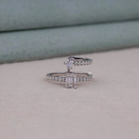 Silver ring with gemstones on a light gray surface