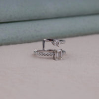 Silver ring with gemstones on a light gray surface