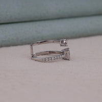 Silver ring with gemstones on a light gray surface