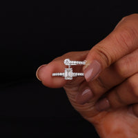 Diamond ring held between fingers against a black background
