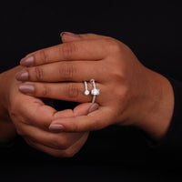 Close-up of a hand wearing a diamond ring on a black background
