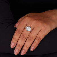 Close-up of a hand wearing a diamond ring on a black background