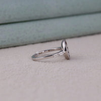Silver ring with a stone on a light gray surface