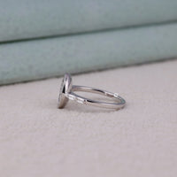 Silver ring with a diamond on a light surface